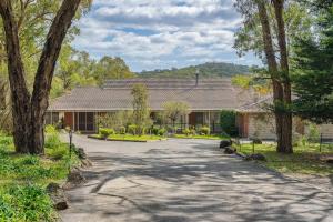 a house with a driveway in front of a building at Peaceful Bushland Retreat with Treetop Hills Views in Wonga Park