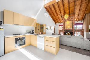 a kitchen with a couch in the middle of a room at Peaceful Bushland Retreat with Treetop Hills Views in Wonga Park