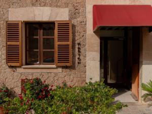 a window on the side of a building with a red awning at Marton Turisme de Interior in Valldemossa