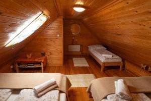 a room with two beds in a wooden cabin at Sklípek Nechory in Prušánky