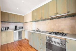a kitchen with stainless steel appliances and wooden floors at Tranquil Cottage with Valley and Hills Views in Wonga Park