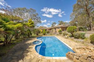 a swimming pool in a yard with a house at Country Charm Cottage with Pool and Forest Views in Wonga Park