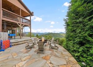 an outdoor patio with a fire pit and benches at Mid-Century Decor Cabin with Stunning Views in Clyde