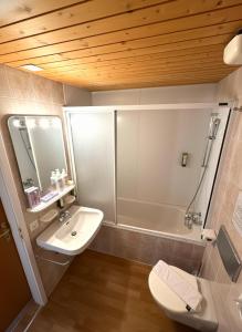 Un baño con lavabo, inodoro y bañera. en Beatenberg Resort & Spa in Beatenberg Interlaken, en Beatenberg 131 fotos más