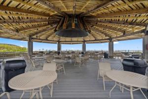 a patio with tables and chairs and a large ceiling at Jetty East, Paradise Palms, Sleeps 4, Pool Private Beach in Destin