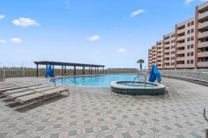a swimming pool with lounge chairs and a building at Jetty East, Paradise Palms, Sleeps 4, Pool Private Beach in Destin