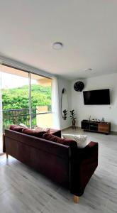 a large couch in a living room with a large window at Apartamento Girardot in Girardot