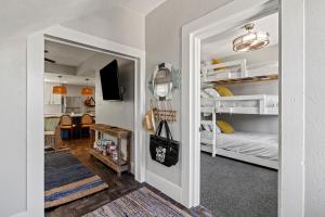 a room with a hallway with bunk beds and a living room at Coastal Escape, Steps to Beach, Fire Pit in Galveston