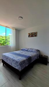 a bedroom with a bed and a large window at Apartamento Girardot in Girardot