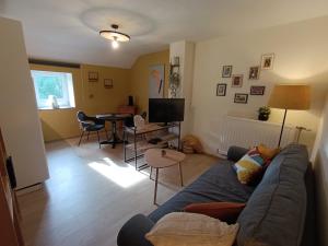 a living room with a blue couch and a table at Entre parenthèses in Barvaux