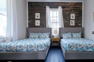 a bedroom with two beds and a window at Historic and charming duplex in desirable midtown, close to the beach and strand in Galveston
