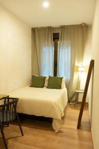 une chambre avec un lit avec des oreillers verts et une fenêtre dans l'établissement Tierra Blanca, à Madrid