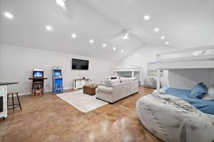 een slaapkamer met een bed, een bank en een tv bij Lakefront home with Pool, Game Room and Dock in Blanchard