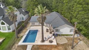 een uitzicht op een huis met een zwembad en palmbomen bij Lakefront home with Pool, Game Room and Dock in Blanchard