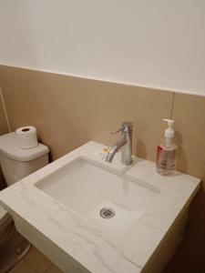 a white sink in a bathroom with a toilet at Sherwood Inn Motel in Brantford