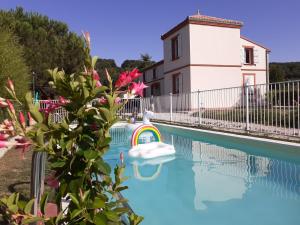 una piscina con una balsa inflable frente a una casa en L'Atelier de la Cascadeta, en La Celle-sous-Gouzon