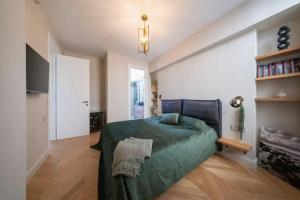a bedroom with a bed with a green blanket at Continental Apartment Unirii in Cluj-Napoca +1 photo