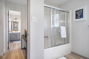 a white bathroom with a shower and a sink at Secluded beachfront house with gorgeous ocean views in Galveston +44 photos