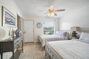 a bedroom with two beds and a ceiling fan at Secluded beachfront house with gorgeous ocean views in Galveston