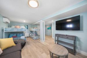 a living room with a couch and a flat screen tv at Cozy beach bungalow close to ocean with large yard in Galveston