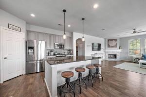 una cucina con isola e sgabelli da bar di Perfect Seabrook retreat just minutes from the bay with fire pit and Cowyboy soaking pool a Seabrook