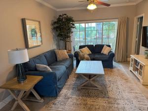 a living room with a blue couch and a table at Modern condo right across from beach and pool in Galveston