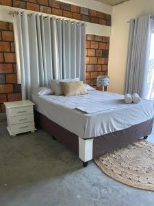 ポンタ・ド・オウロにあるlodge3aのレンガの壁のベッドルーム1室(大型ベッド1台付)