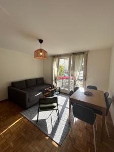 a living room with a couch and a table and chairs at Basic Flat with Balcony in Zurich in Zurich