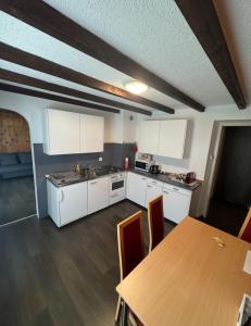 a kitchen with white cabinets and a wooden table at Casa Angelica in Quinto +5 photos