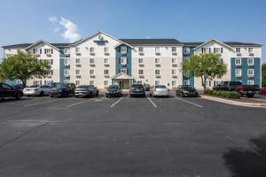 a large building with cars parked in a parking lot at Woodspring Suites Huntsville/ Madison in Madison