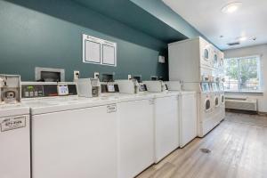 a laundry room with white washer and dryers at Woodspring Suites Huntsville/ Madison in Madison
