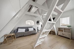 a loft bedroom with a bed and a ladder at Cozy A-frame with Fenced Yard, Fire Pit, Gulf View in Surfside Beach