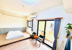 a bedroom with a bed and a table and chairs at 竺韵旅宿 in Zhushan