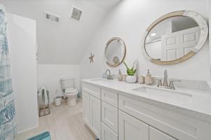 a white bathroom with a sink and a mirror at Bright and Cozy 4 Bedroom close to the Ocean in Galveston +31 photos