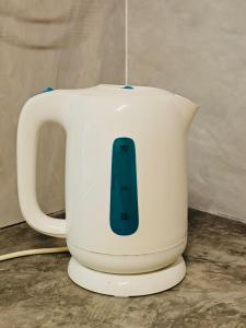a white jug with a remote control in it at Guesthouse 20 - Free WiFi, Netflix & snacks in Banting +6 photos