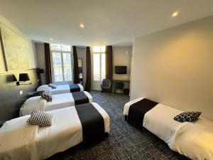 ein Hotelzimmer mit drei Betten und einem Fernseher in der Unterkunft Trocadero in Nizza