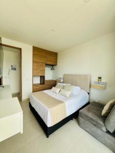 ein Schlafzimmer mit einem großen Bett und einer Couch in der Unterkunft Nuevo apto familiar cerca al mar in Santa Marta + 25 Fotos