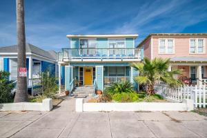 a blue and pink house with a white fence at Seawall Sunrise-Close to Beach in Galveston