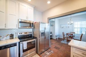 a kitchen with a stainless steel refrigerator and a dining room at Seawall Sunrise-Close to Beach in Galveston