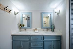 a bathroom with two sinks and two mirrors at Seawall Sunrise-Close to Beach in Galveston +41 photos