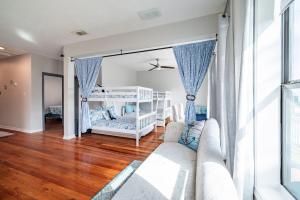 a living room with a couch and a bunk bed at Seawall Sunrise-Close to Beach in Galveston