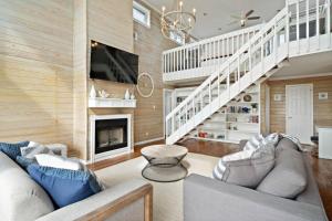 een woonkamer met een bank en een open haard bij Secluded beachfront home with panoramic ocean views, private pool and huge deck in Hercules Offshore Heliport