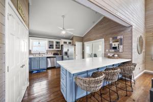 een keuken met een blauw eiland met barkrukken bij Secluded beachfront home with panoramic ocean views, private pool and huge deck in Hercules Offshore Heliport