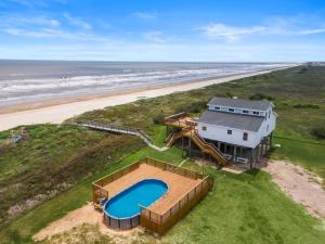 een luchtfoto van een huis met een zwembad naast het strand bij Secluded beachfront home with panoramic ocean views, private pool and huge deck in Hercules Offshore Heliport