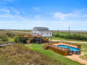 een luchtfoto van een huis met een zwembad bij Secluded beachfront home with panoramic ocean views, private pool and huge deck in Hercules Offshore Heliport