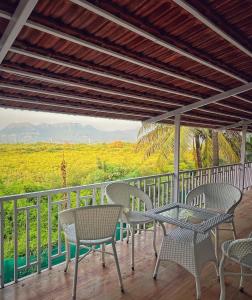 a table and chairs on a balcony with a view at Cayana Palms in Sāhān