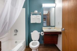 a bathroom with a toilet and a sink and a mirror at Woodspring Suites Huntsville/ Madison in Madison +17 photos