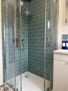 a bathroom with a shower with green tiles at Parliament House in Ellesmere Port