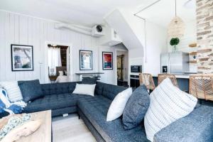 ein Wohnzimmer mit einer blauen Couch und einer Küche in der Unterkunft Historic Galveston homes, close to all the island has to offer in Galveston