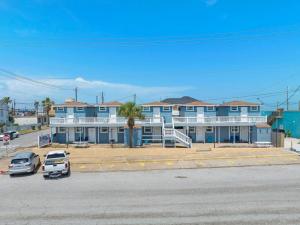 a blue building with cars parked in a parking lot at Cozy ocean view condo on Galvestons east end, close to cruise terminal in Galveston +28 photos